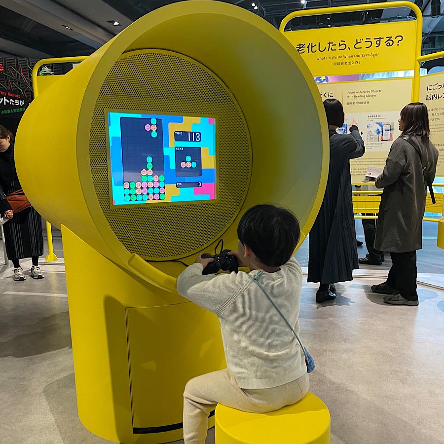 日本科学未来館の新常設展、老いパーク。目の老化を体感するゲーム。ゲームをする息子。