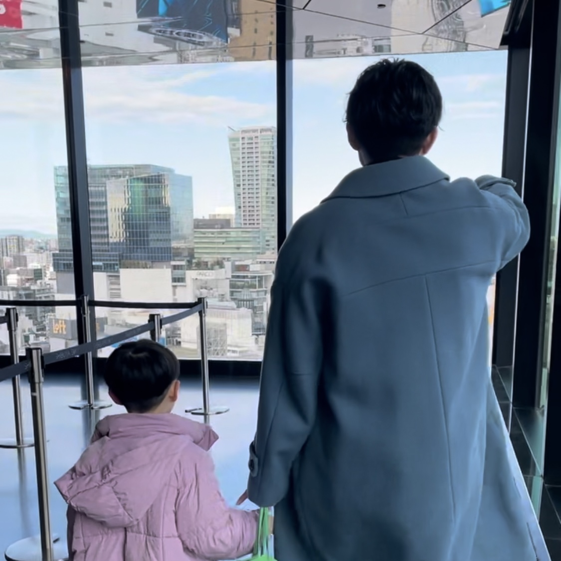 渋谷スカイのエレベーターにのるまでの道のりを歩く父と息子。